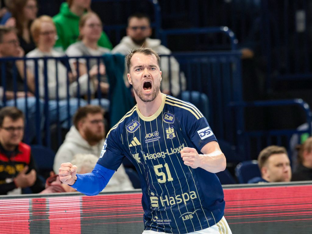 Handballspieler #51 im blauen Trikot jubelt nach einem Treffer