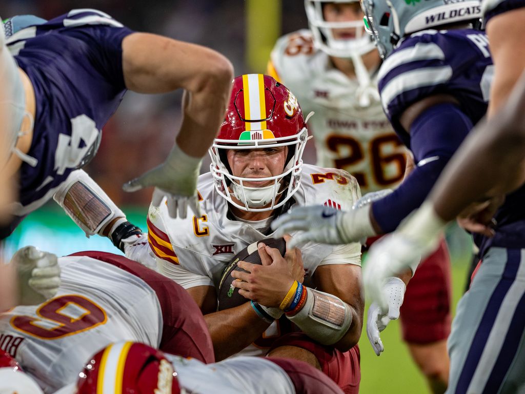 American-Football-Quarterback im roten Helm wird von der Defense angegriffen
