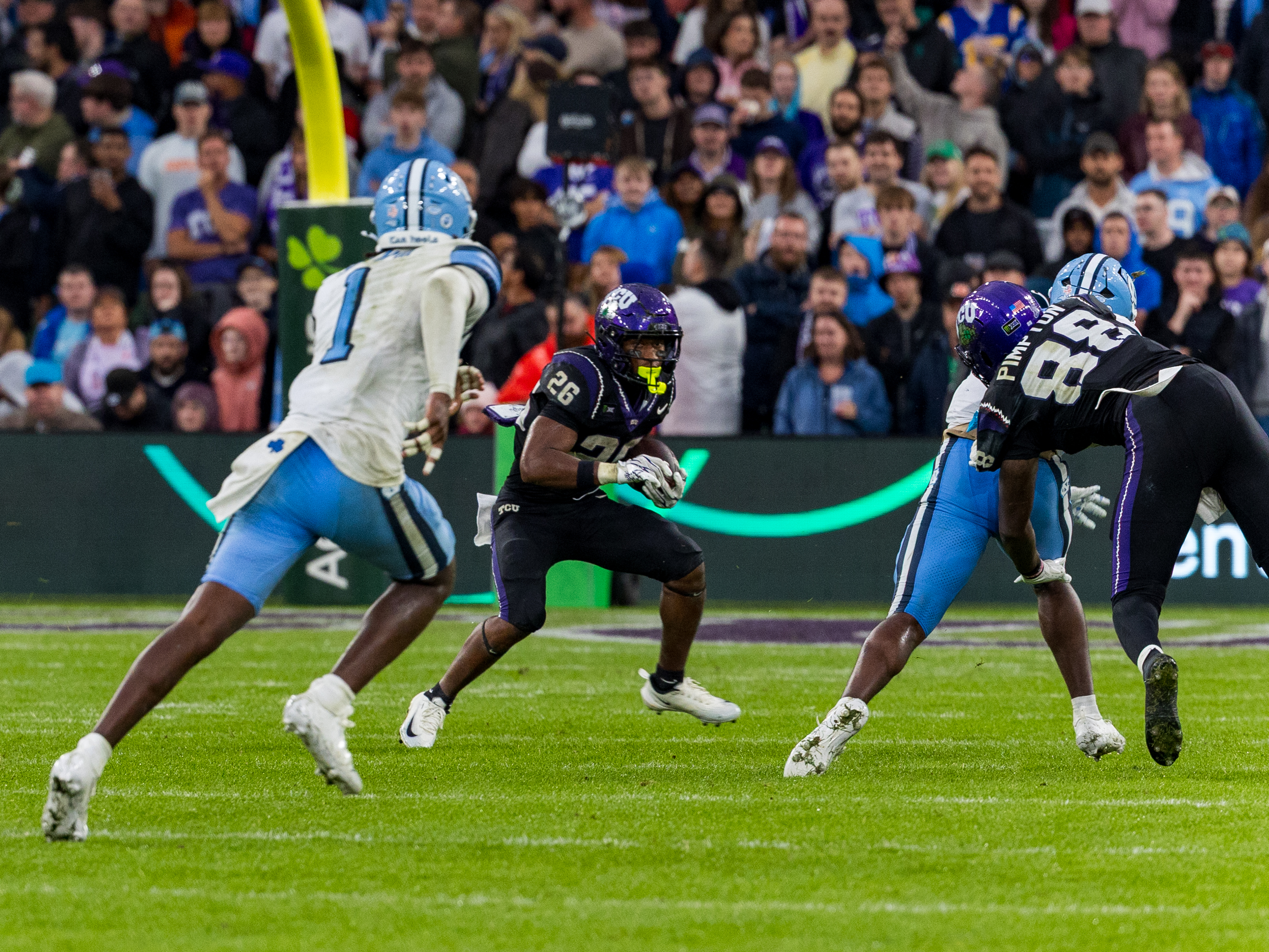#26 Jeremy Payne (RB) TCU Horned Frogs run with the ball. #1 Greg Smith (DB) University of North Carolina Tar Heels on the way to tackle.