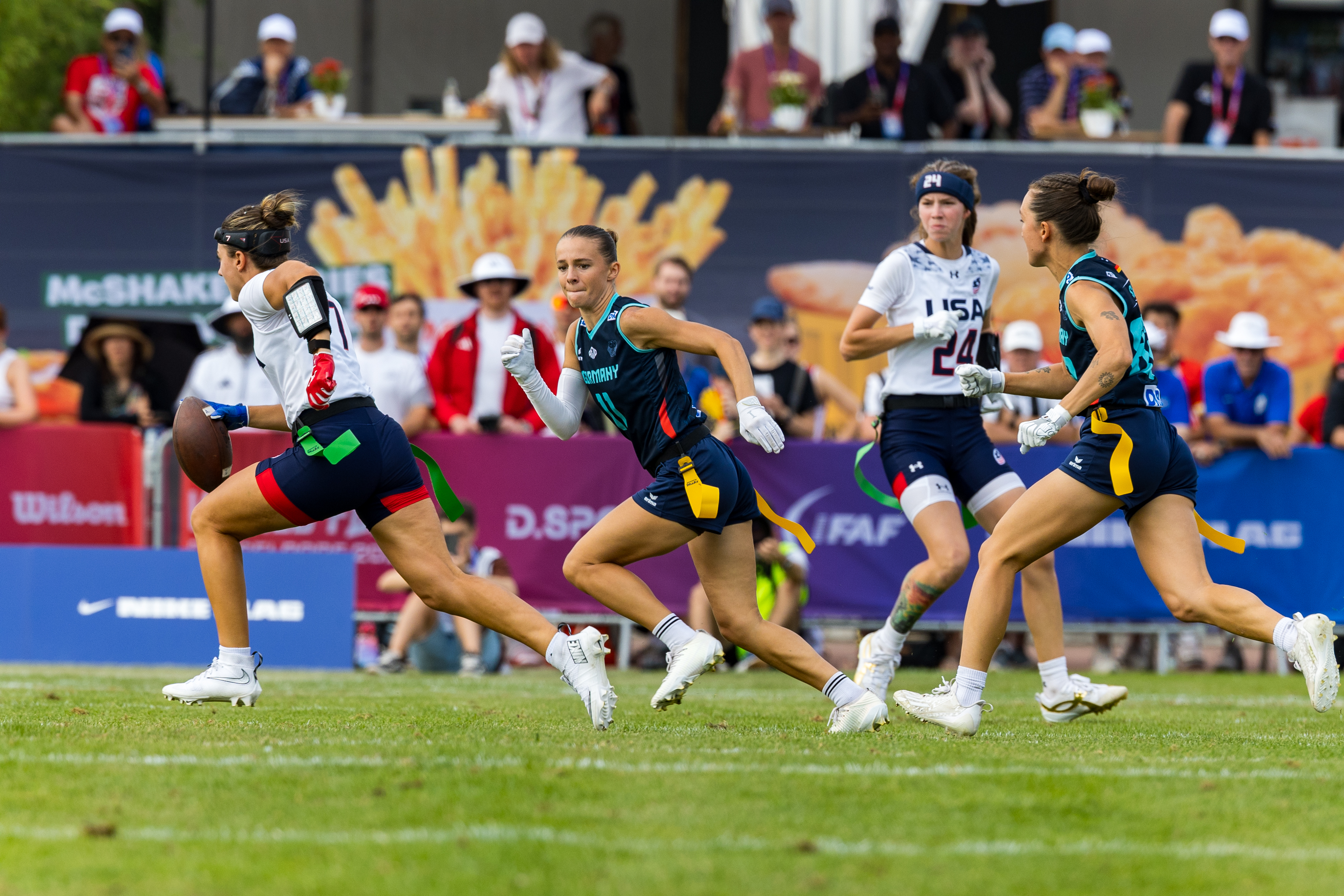 #7 Maci Joncich (WR/QB) Team USA Women run with the ball. #11 Hannah Charlotte Bahn (DB) Team Germany Women follow her.