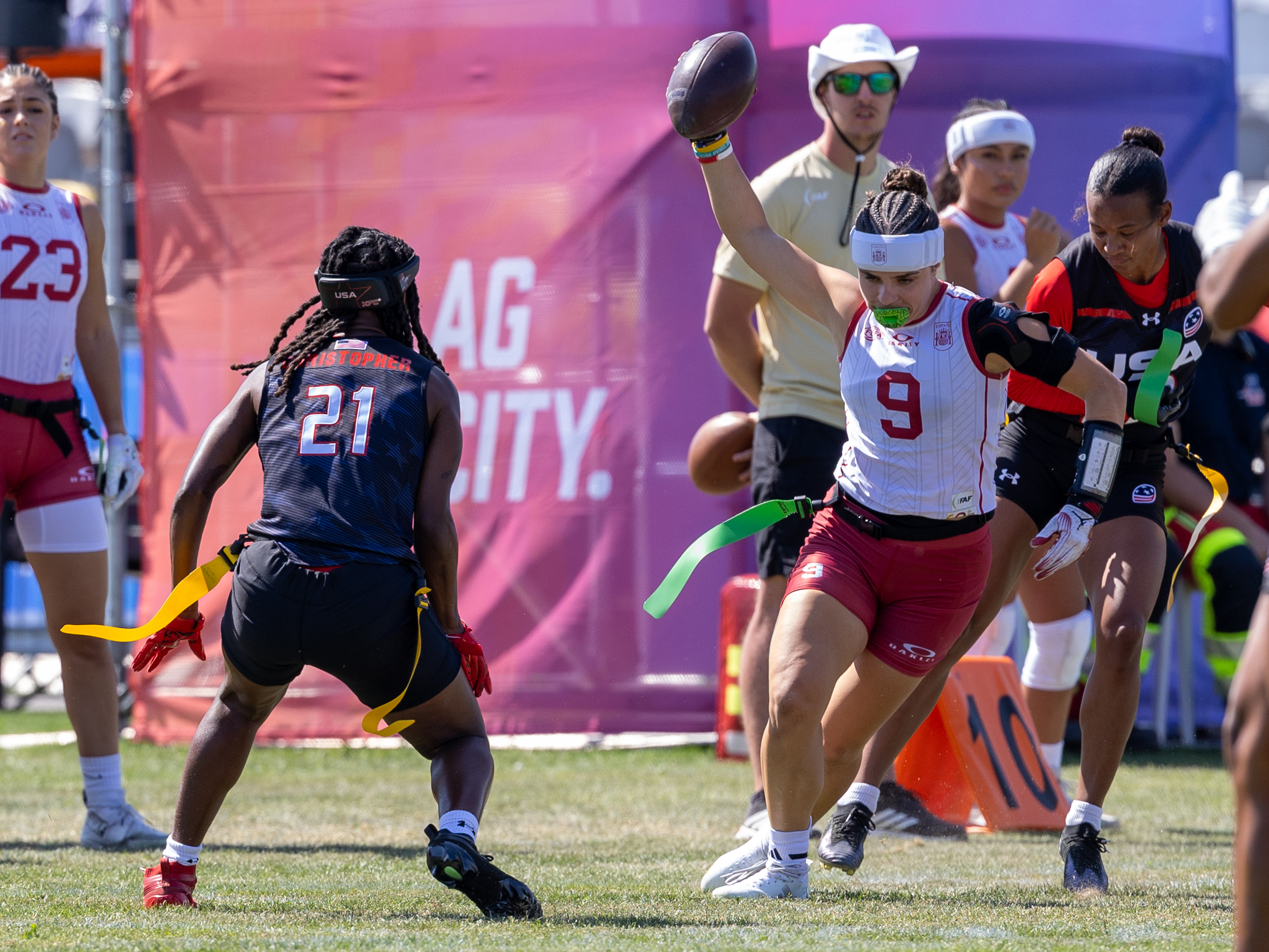 #9 Olga Sotillo Val (WR/DB) Team Spain Women run with the ball. #21 NyKeeta Christopher (DB/WR) Team USA Women wait for catch the flag.