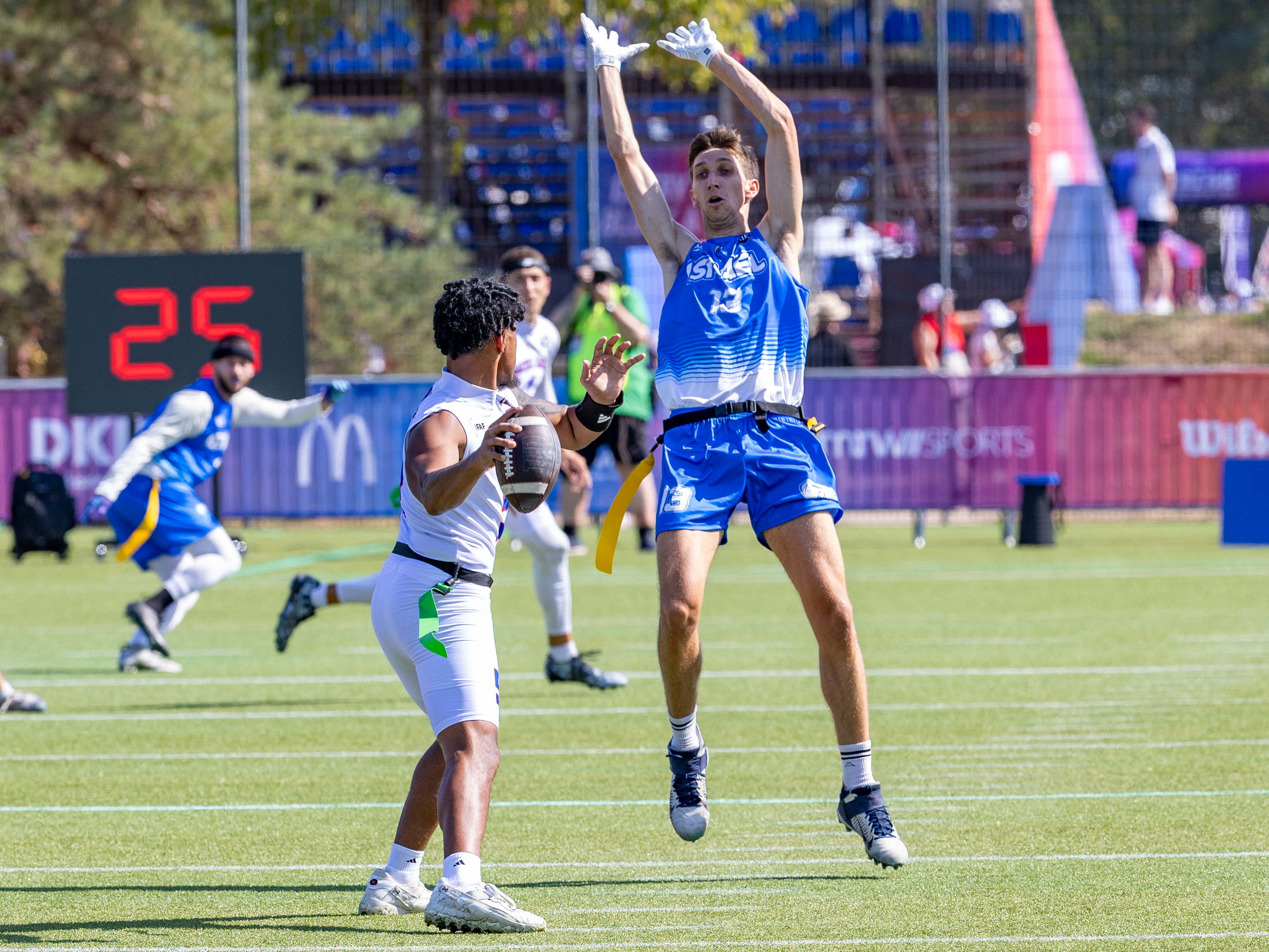#13 MICHAEL TOVER (WR) Team Israel Men jump hight to block the pass. #5 Taulia Tagovailoa (QB) Team American Samoa Men search a target