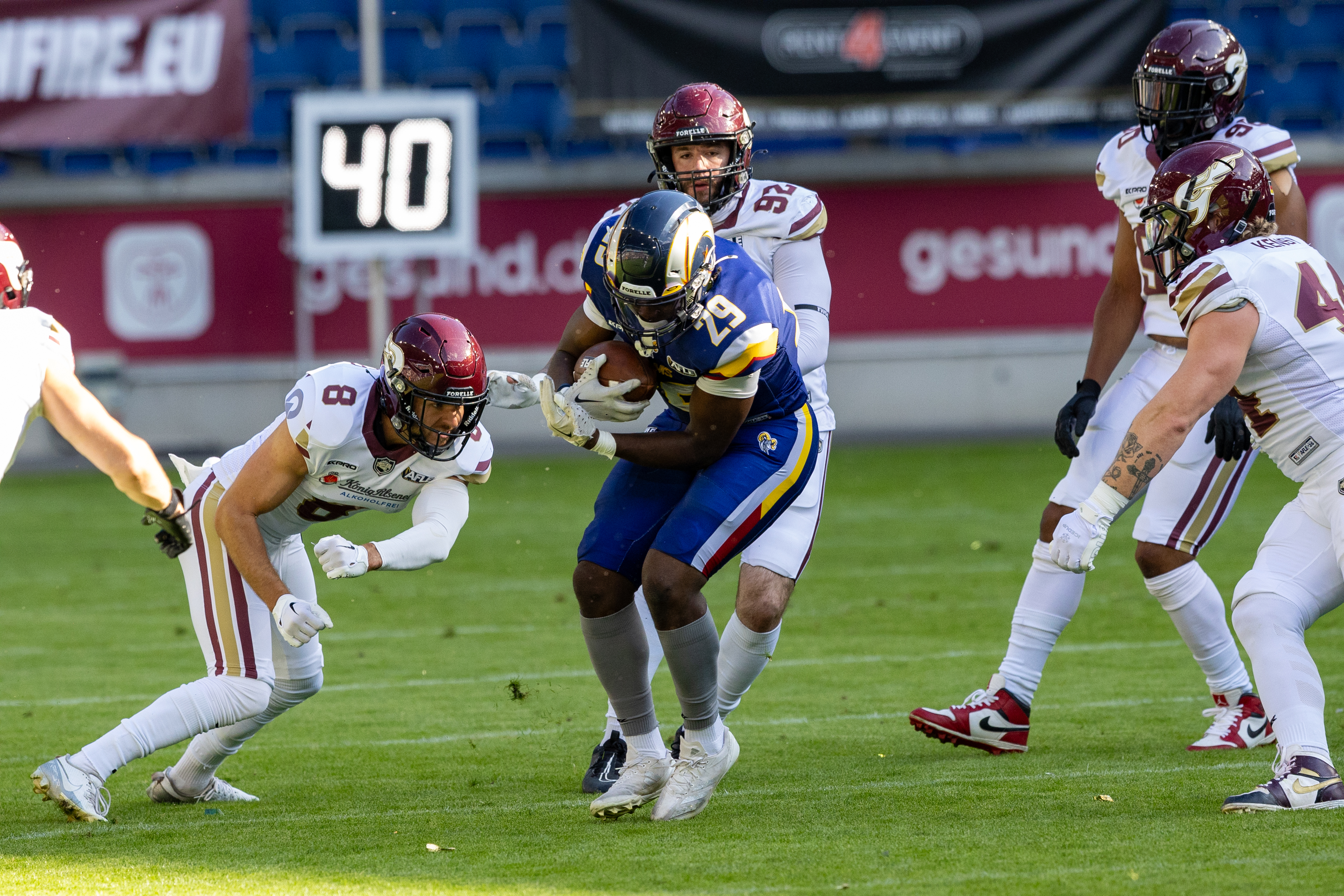 #29 Lionel Bangala (Running Back) – Alpine Rams run with the ball. #8 Max Richter (Strong Saftey) – Rhein Fire on the way to tackle.