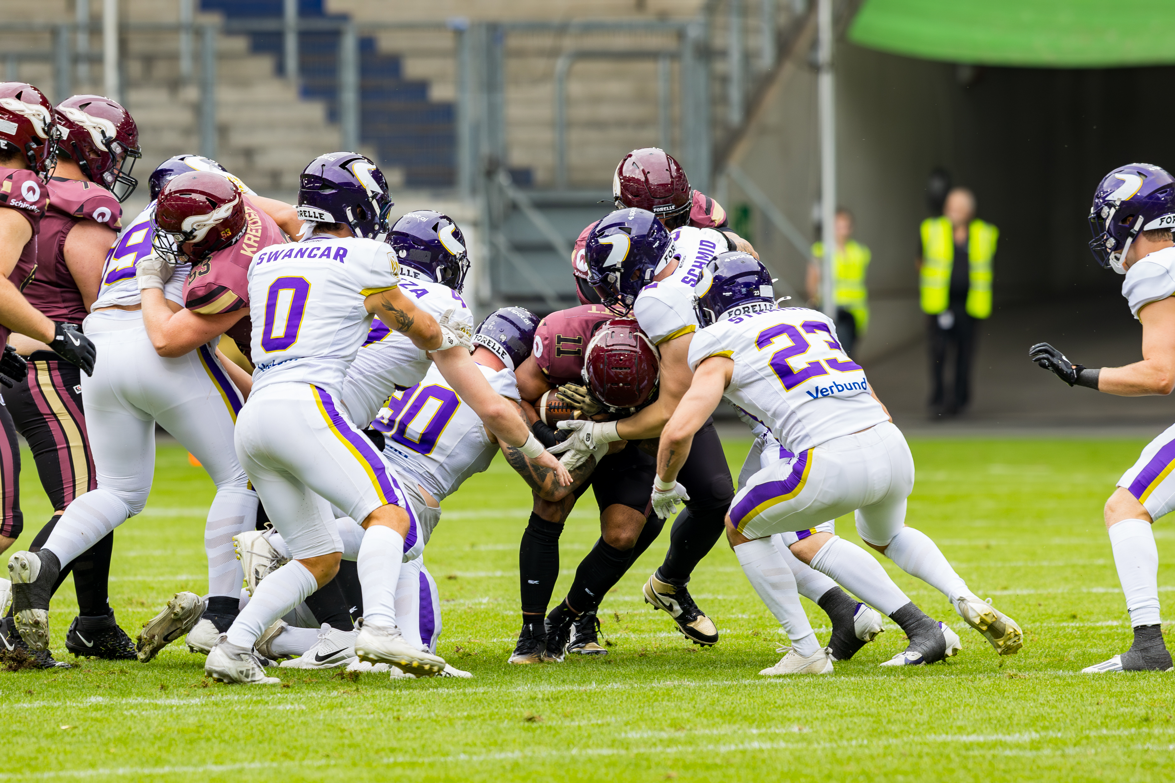 #23 Benjamin Straight (Strong Safety / Punter) – Vienna Vikings, #90 Manuel Radfux (Defensive Tackle) – Vienna Vikings and #0 Noel Swancar (Linebacker) – Vienna Vikings tackle #11 Jonathan Scott (Halfback) – Rhein Fire