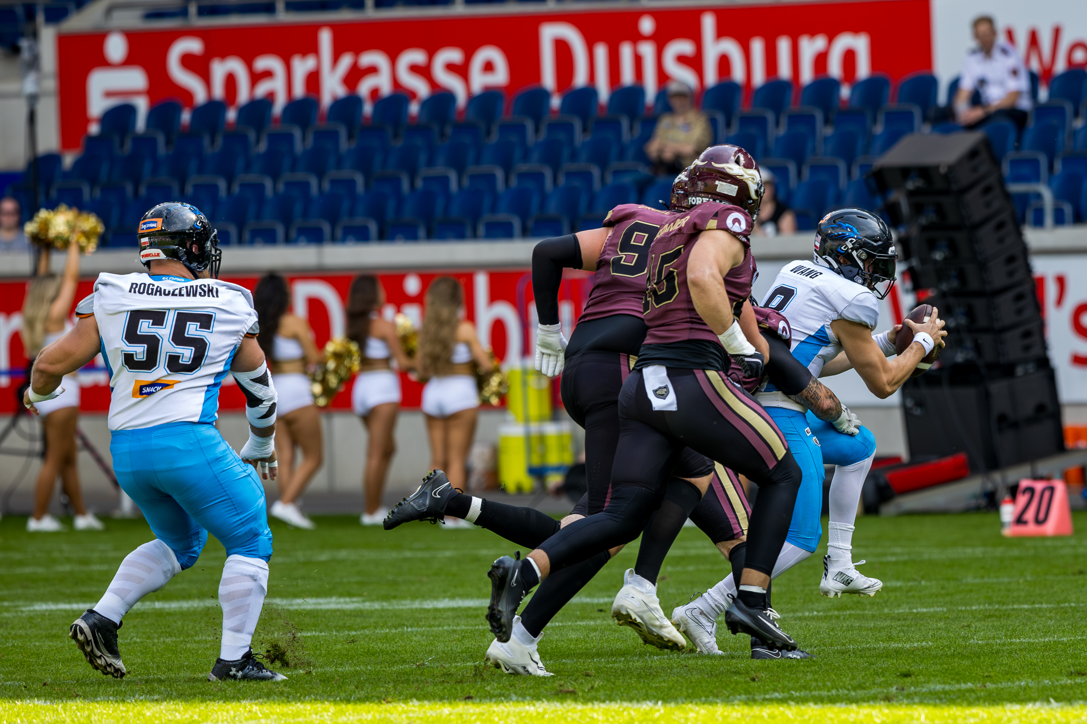 #8 Jameson Wang (Quarterback) – Panthers Wroclaw run with the ball. #55 Luis Fiedler (Linebacker) – Rhein Fire follow him.