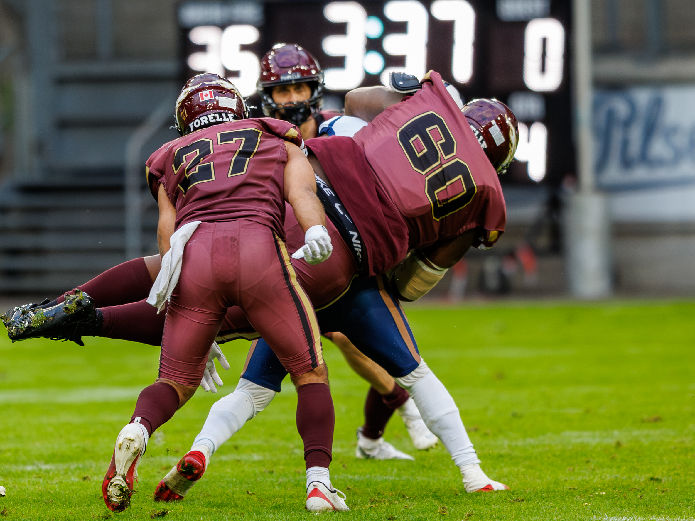 #60 Musa Bajaha (Defensive Tackle) – Rhein Fire and #27 Justin Howell (Defensive Back) – Rhein Fire tackle #21 Jean-Charles Moukouri (Running Back) – Paris Lights