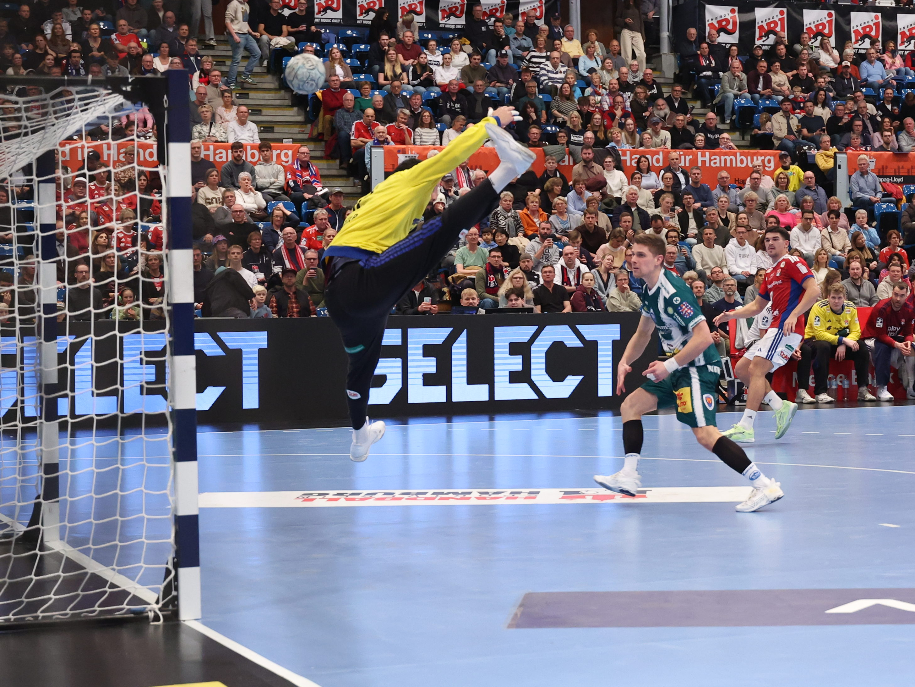 #14 Peter Walz (Kreis) – ThSV Eisenach wirft aufs Tor. #12 Mohamed El-Tayar (Torwart) – Handball Sport Verein Hamburg blockt den Ball.