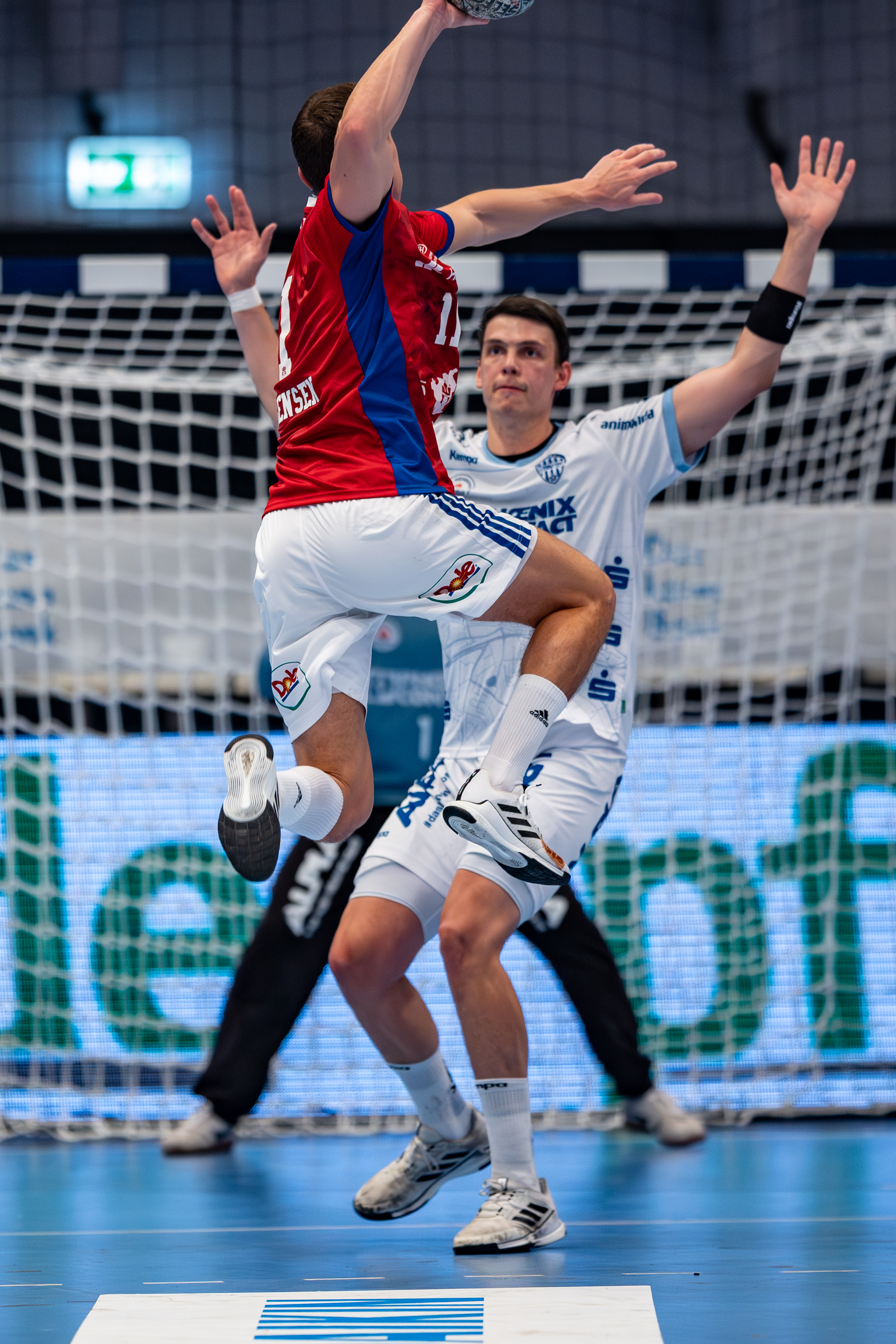 #8 Frederik Simak (Linksaußen) – TBV Lemgo Lippe block and #11 Nicolaj Jørgensen (Rückraum Mitte) – Handball Sport Verein Hamburg jump