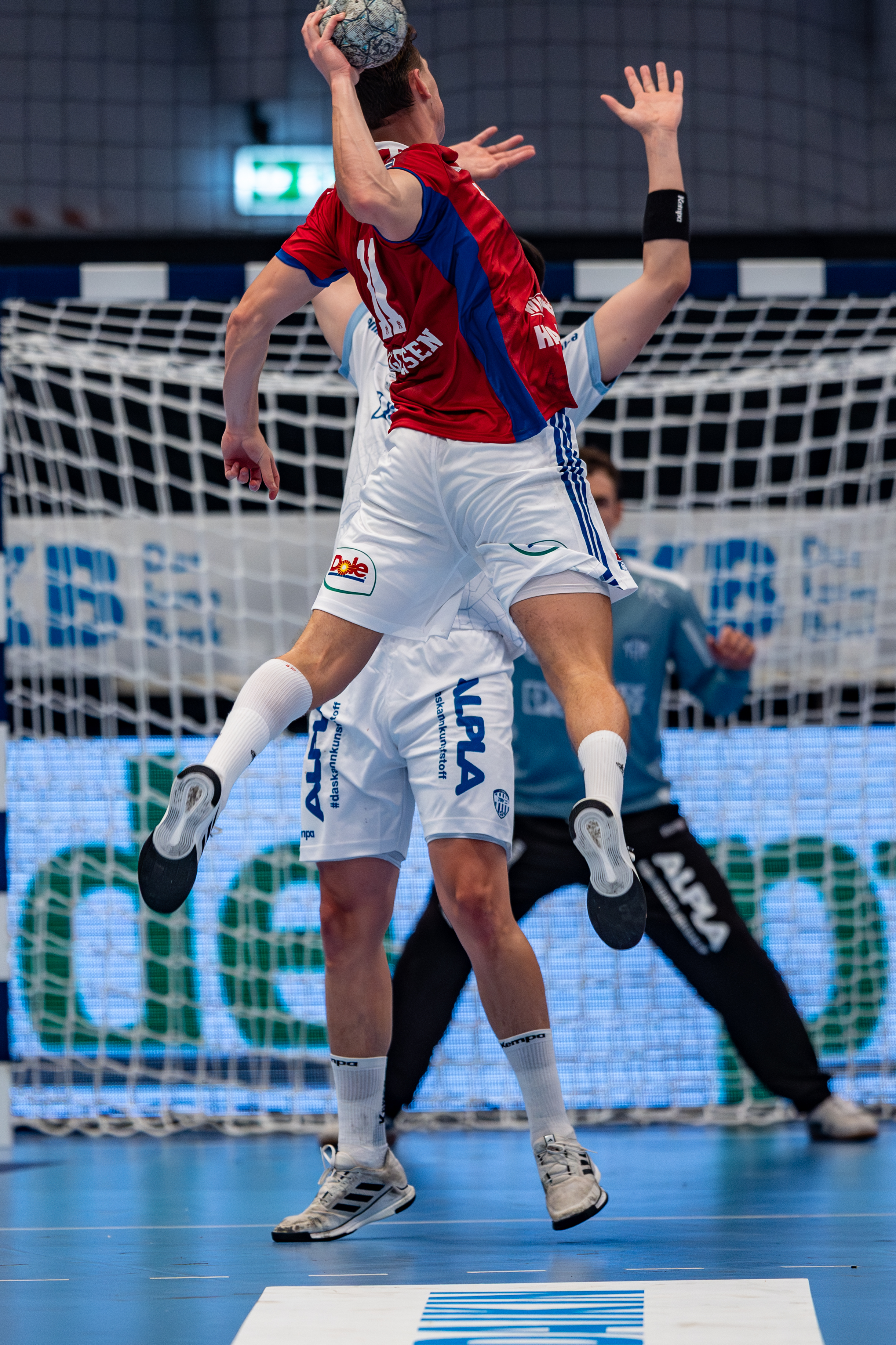 #8 Frederik Simak (Linksaußen) – TBV Lemgo Lippe block and #11 Nicolaj Jørgensen (Rückraum Mitte) – Handball Sport Verein Hamburg jump